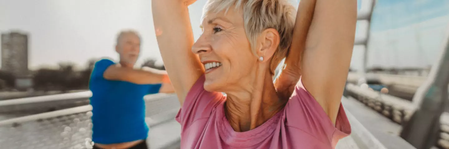 Senior und Seniorin machen draußen Sport