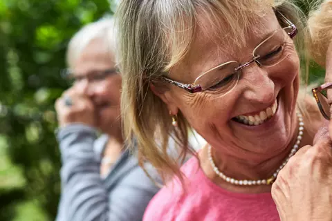 Drei Seniorinnen sind draußen unterwegs und haben Spaß