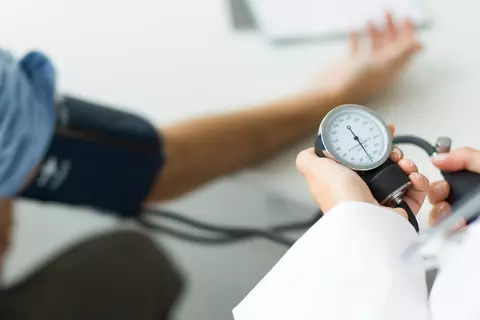 Arzt misst den Blutdruck bei einem Patienten