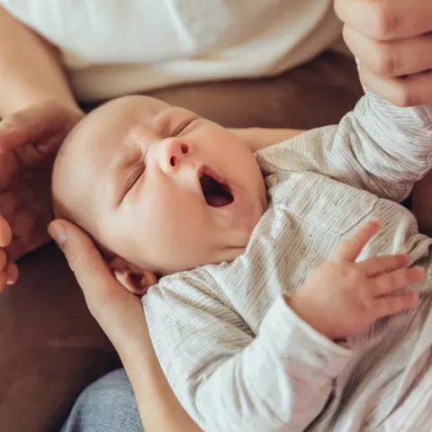 Frauen die ein schreiendes Baby halten